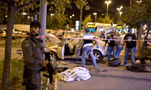 An Israeli border policeman stands guard next to the attack site - Photo: The Guardian